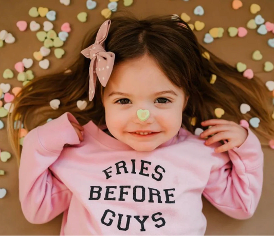 Preschool girl smiling in pink Fries Before Guys sweatshirt with heart headband