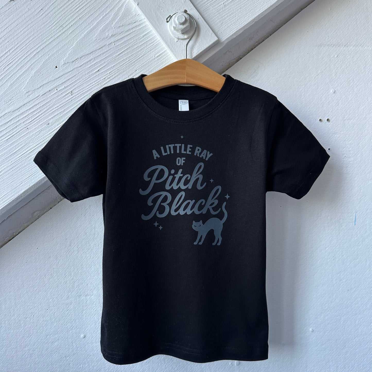 Black hoodie with text and graphic on a light wooden surface