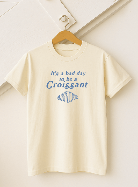 Adult Croissant T-shirt by The Wishing Elephant featuring a detailed croissant graphic on a casual tee shirt.