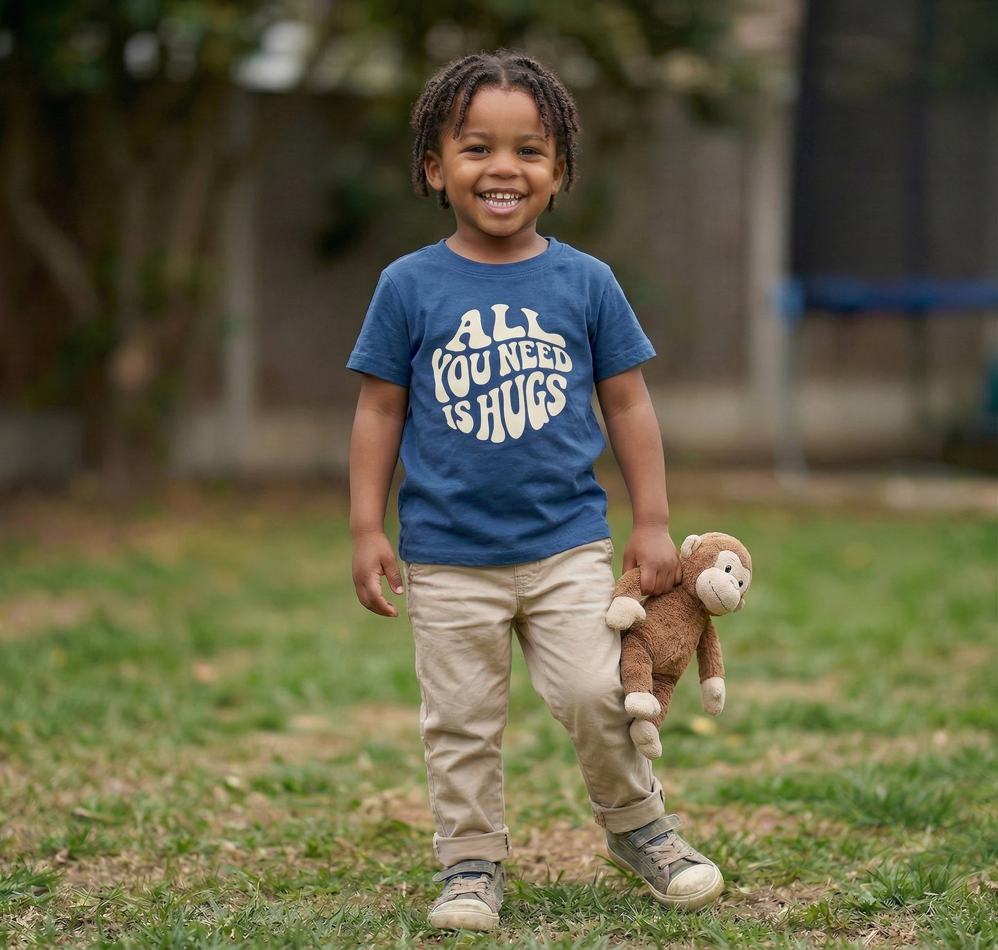 Kids graphic T-shirt by The Wishing Elephant with "All You Need Is Hugs" print, featuring a soft fabric and colorful design for children.