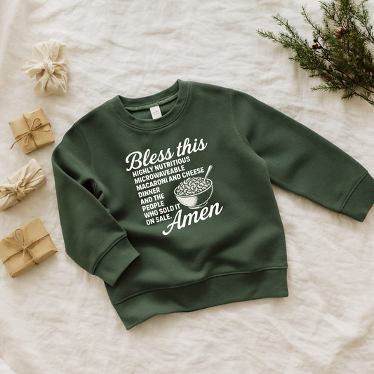 Green sweatshirt with humorous text design on a light background home alone bless this mac and cheese