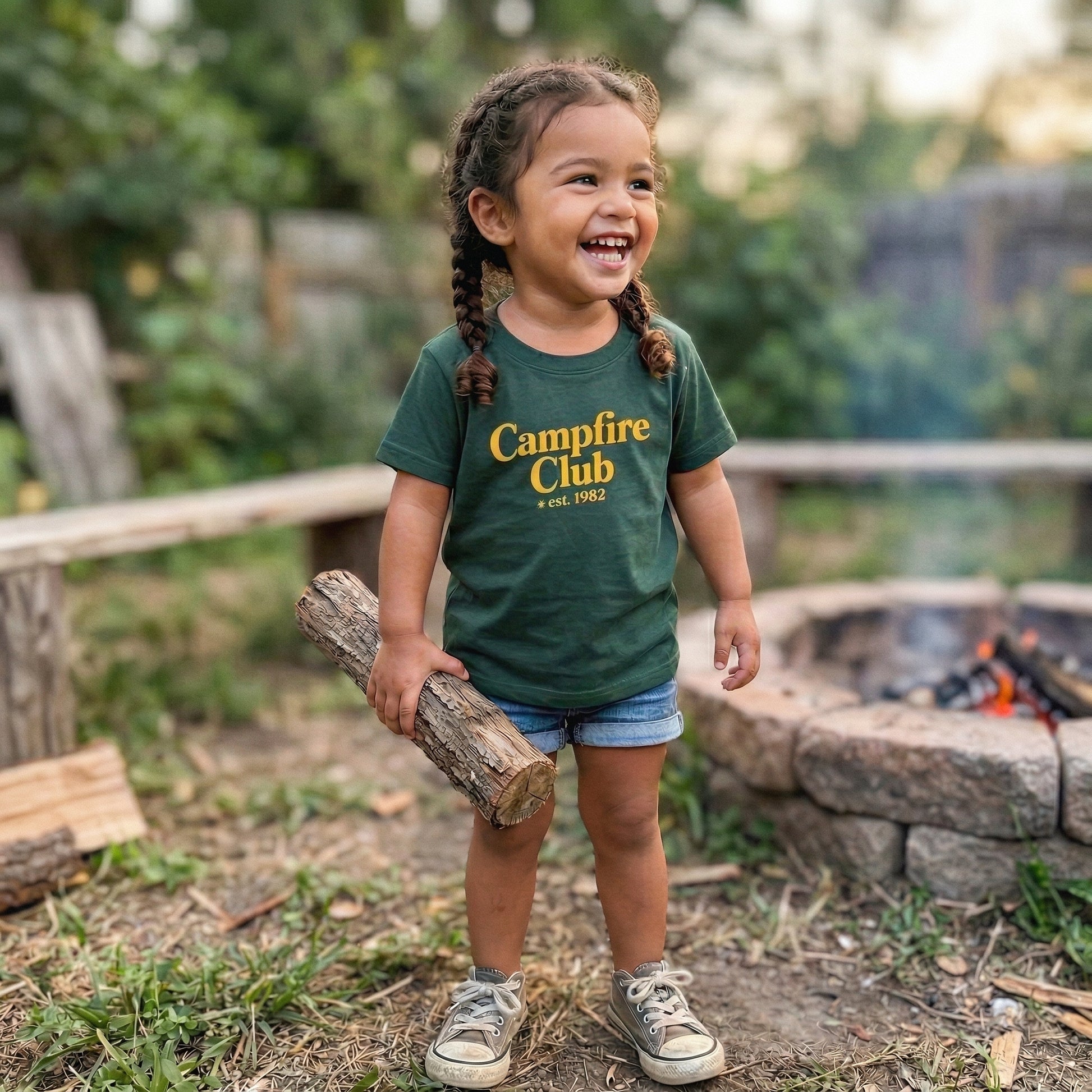 Green Kids' graphic T-shirt from The Wishing Elephant featuring a campfire design, perfect for summer wear.