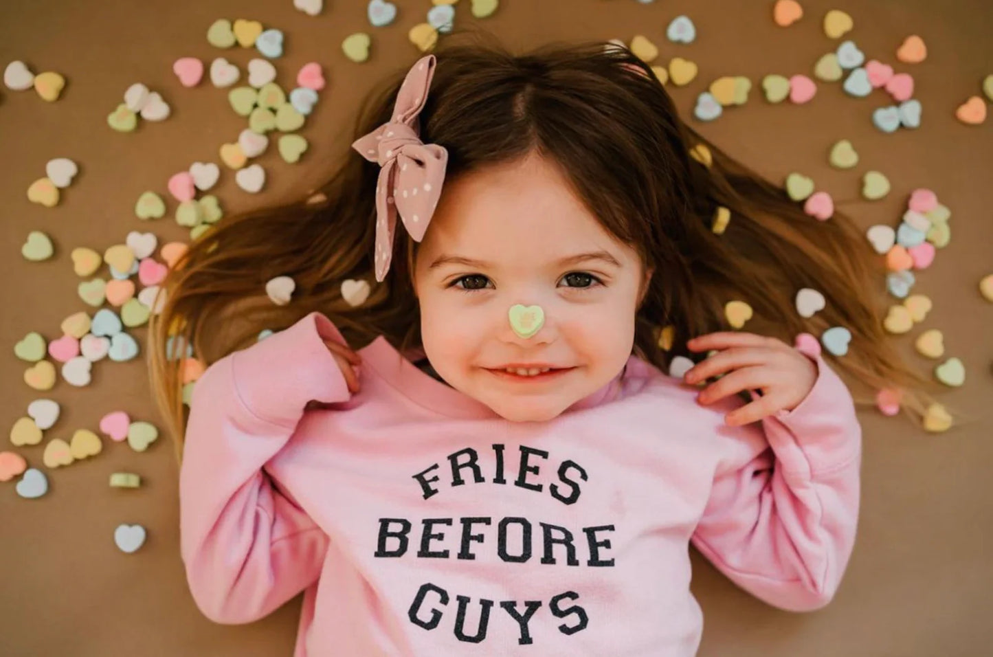 Preschool girl smiling in pink Fries Before Guys sweatshirt with heart headband