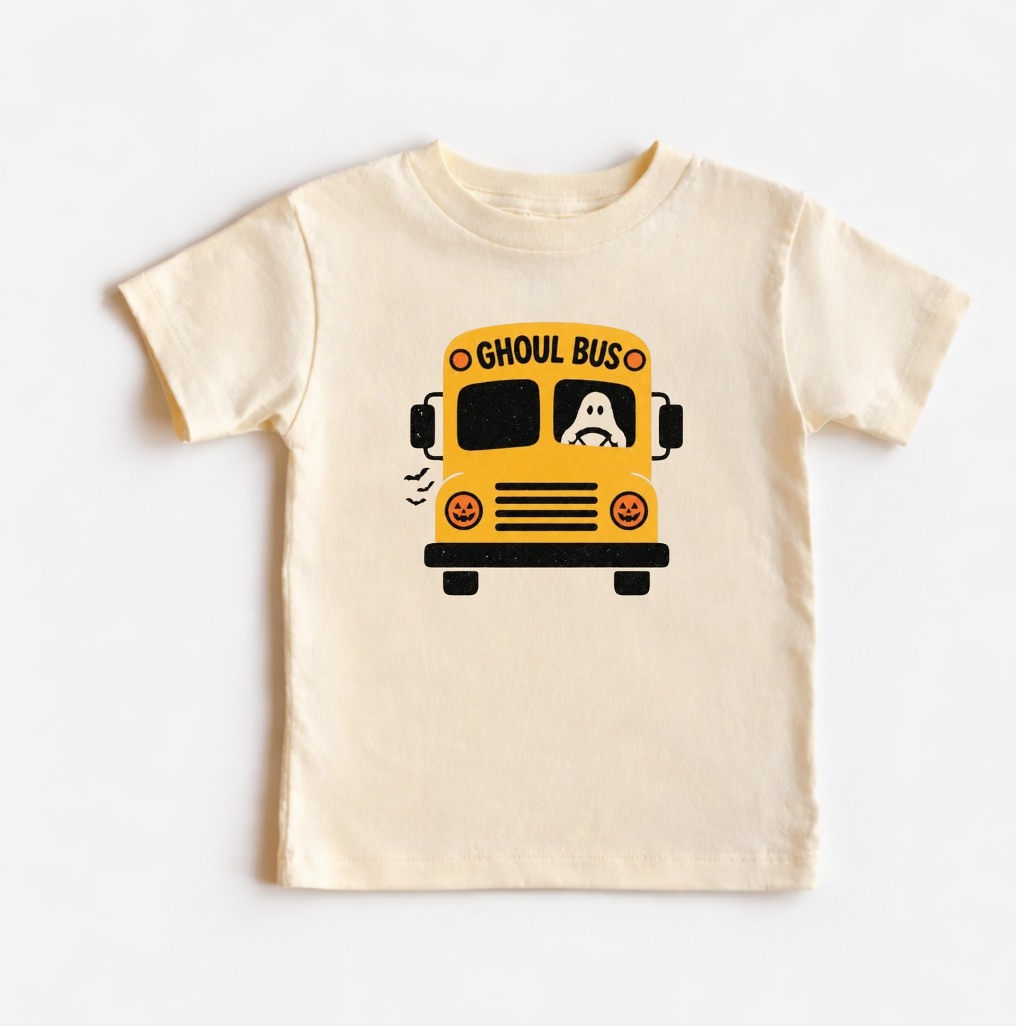 A cream-colored short-sleeve baby t-shirt featuring a cartoon graphic of a yellow school bus with a ghost inside, labeled 'GHOUL BUS'.