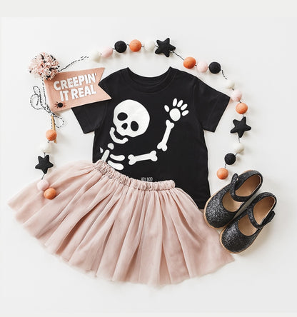 Black skeleton t-shirt with pink skirt and black shoes on a white background