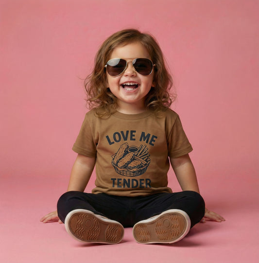 Child wearing sunglasses and a brown t-shirt with text and graphics on a pink background