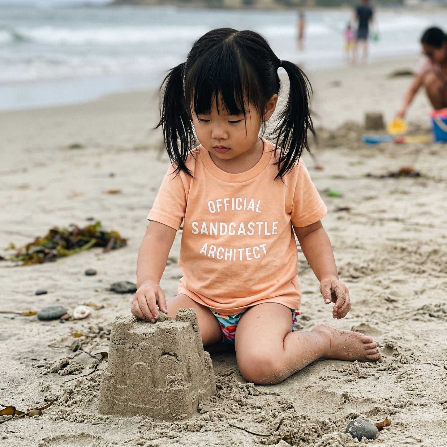 Kids graphic T-shirt from The Wishing Elephant featuring a playful sandcastle architect design for summer beach fun.