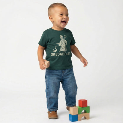 child playing in green saint patricks day graphic shirt that says skedaddle with Saint Patrick playfully driving the snakes out